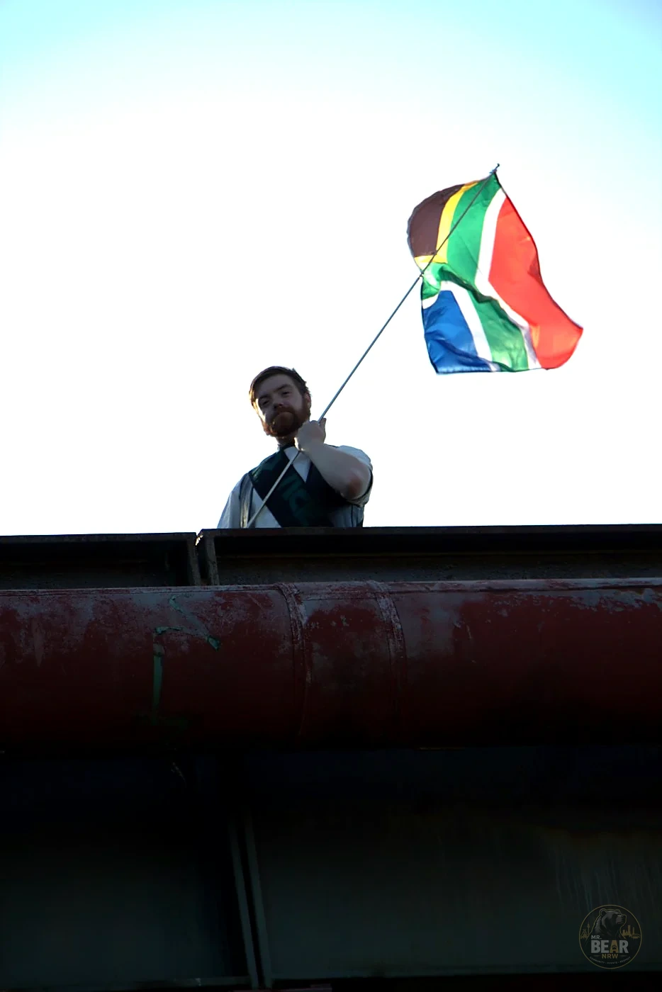 Joshua mit südafrikanischer Flagge vor der Industriekulisse